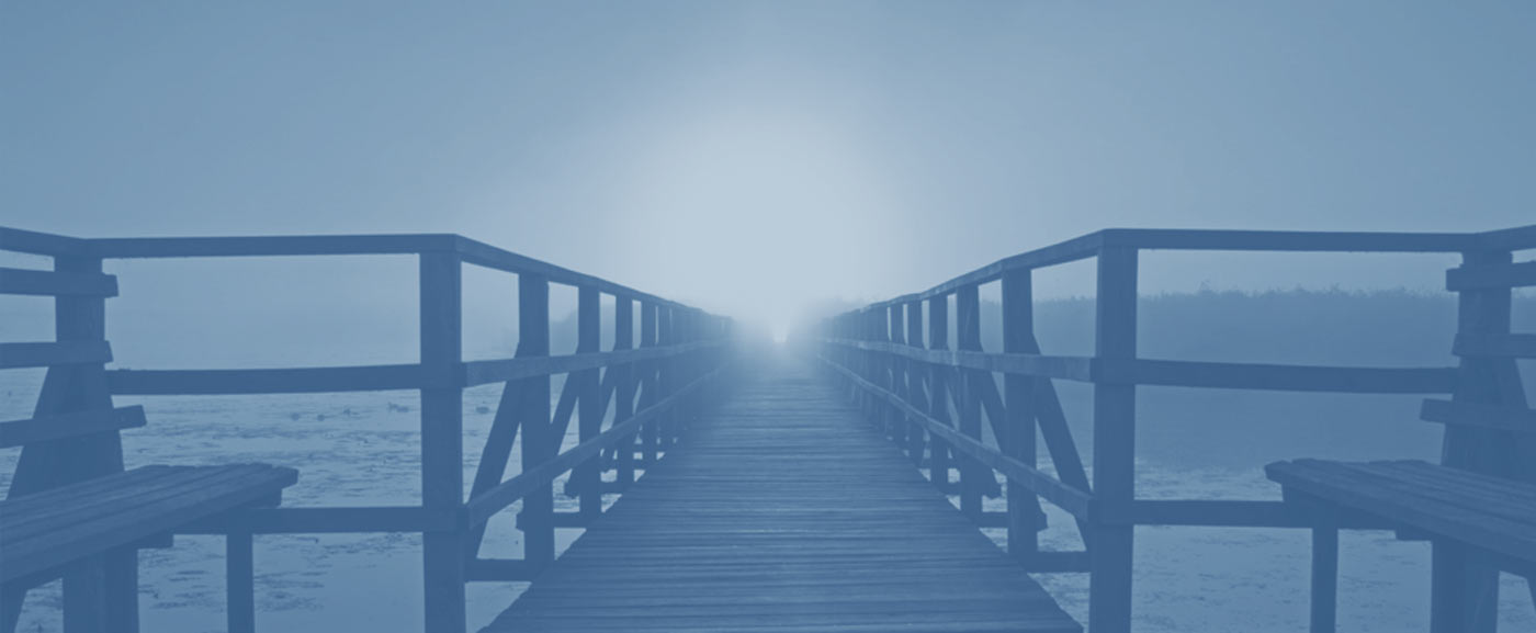 a pier leading into the ocean, a sunset in the background